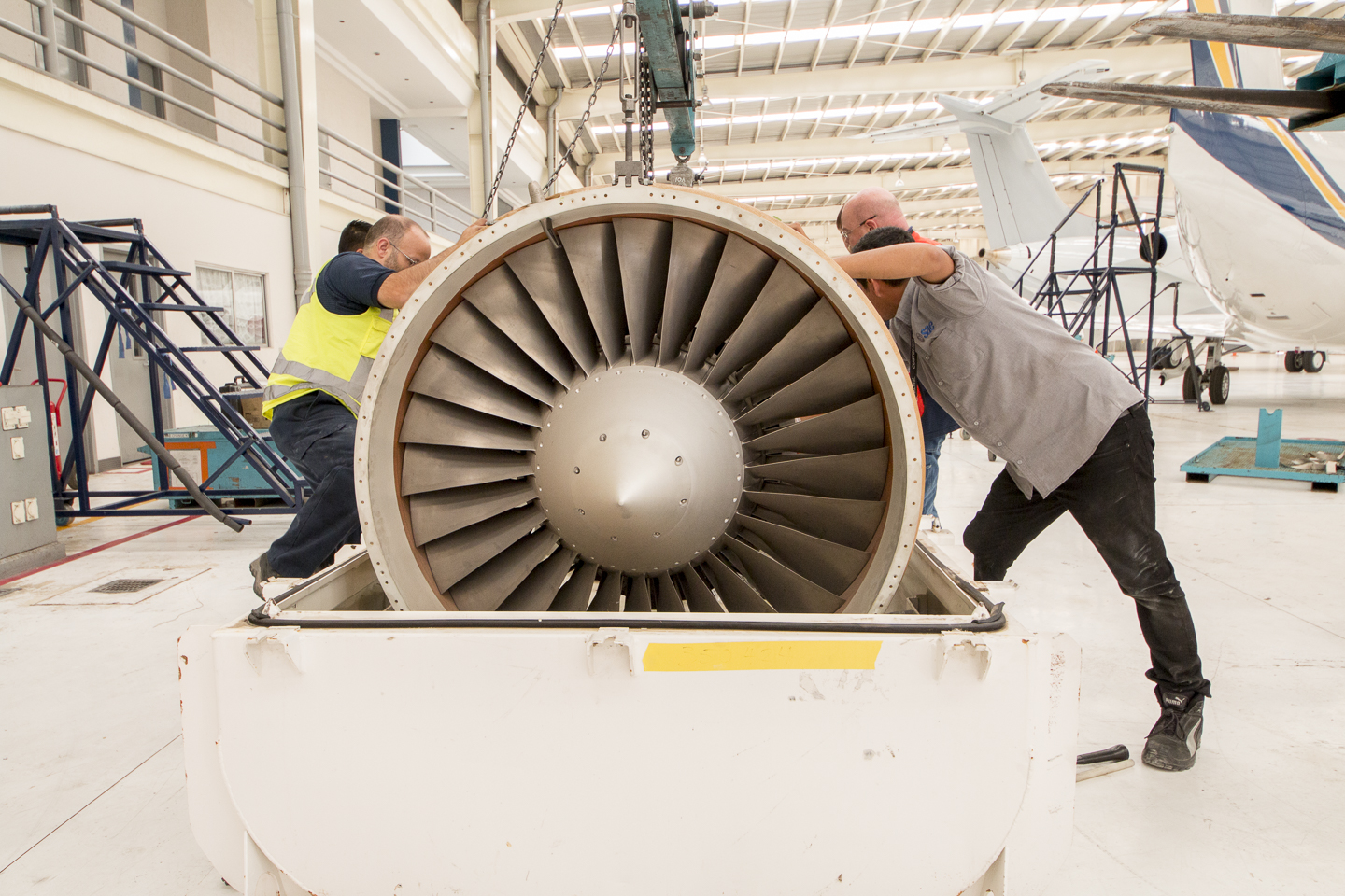 Técnicos maniobrando una turbina en el hangar de CIMA Aviación